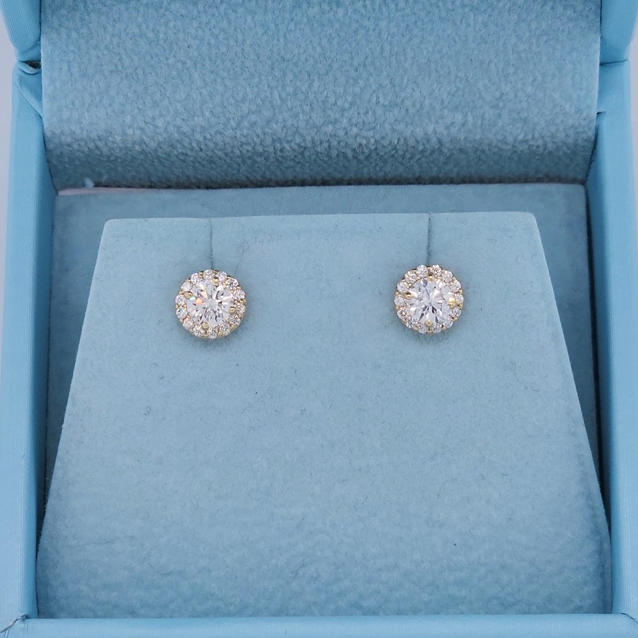Close-up of 14k yellow gold halo diamond stud earrings featuring natural round cut diamonds, SI clarity, G-H color, with a secure push back setting and elegant sparkle.