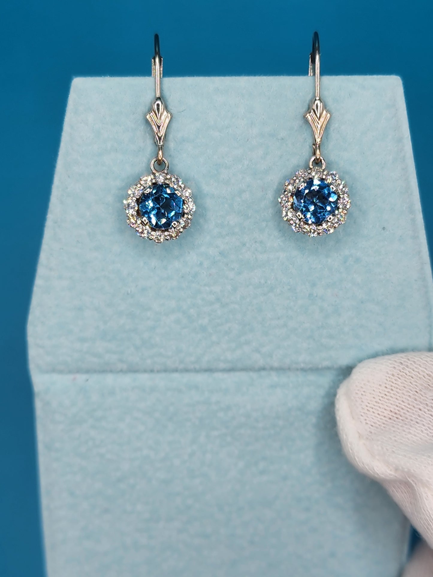 Blue Topaz and Halo Diamonds Dangling Earrings in 14k White Gold