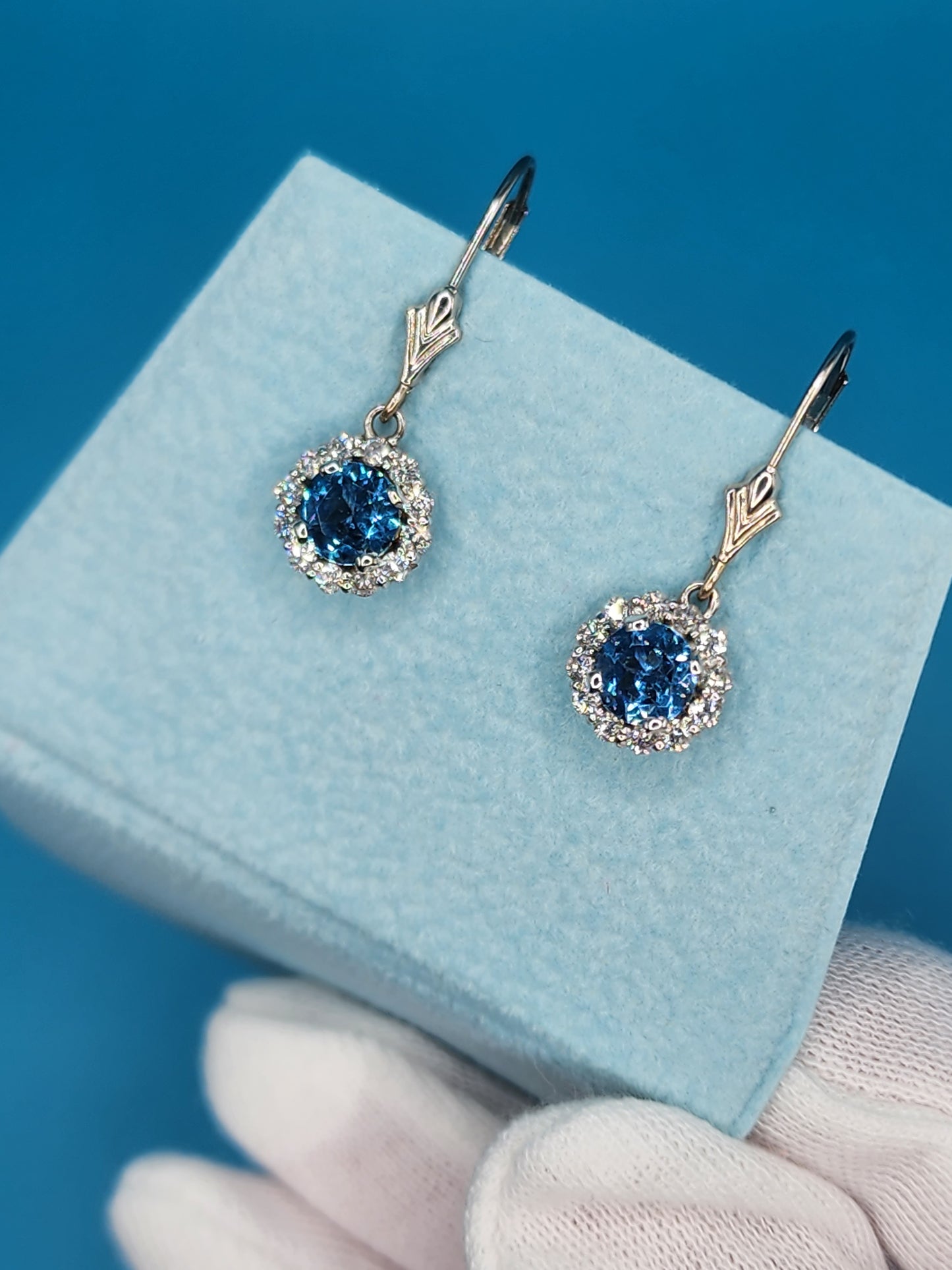 Blue Topaz and Halo Diamonds Dangling Earrings in 14k White Gold