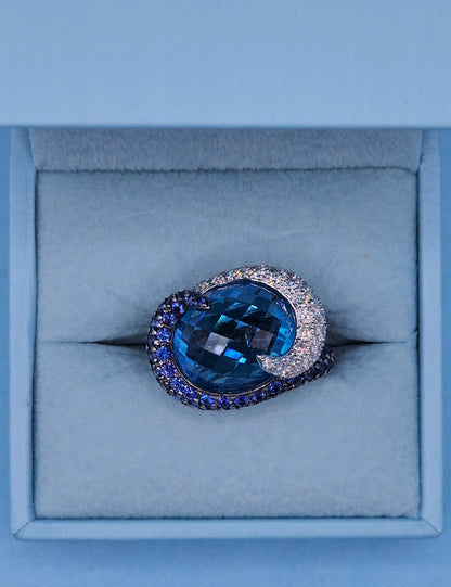 Large Cocktail Ring with Blue Topaz Center Accented by Diamond and Sapphire Swirl in 18k White Gold