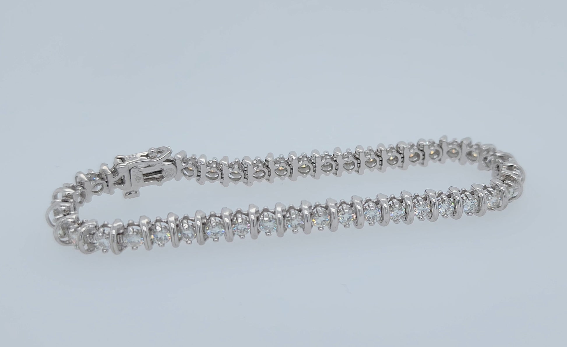 14k white gold moissanite tennis bracelet with bar-style setting, double safety clasp, 7.25 inches long, approx. 5 carat total weight, 5.7 mm wide, elegant and luxurious wristwear.