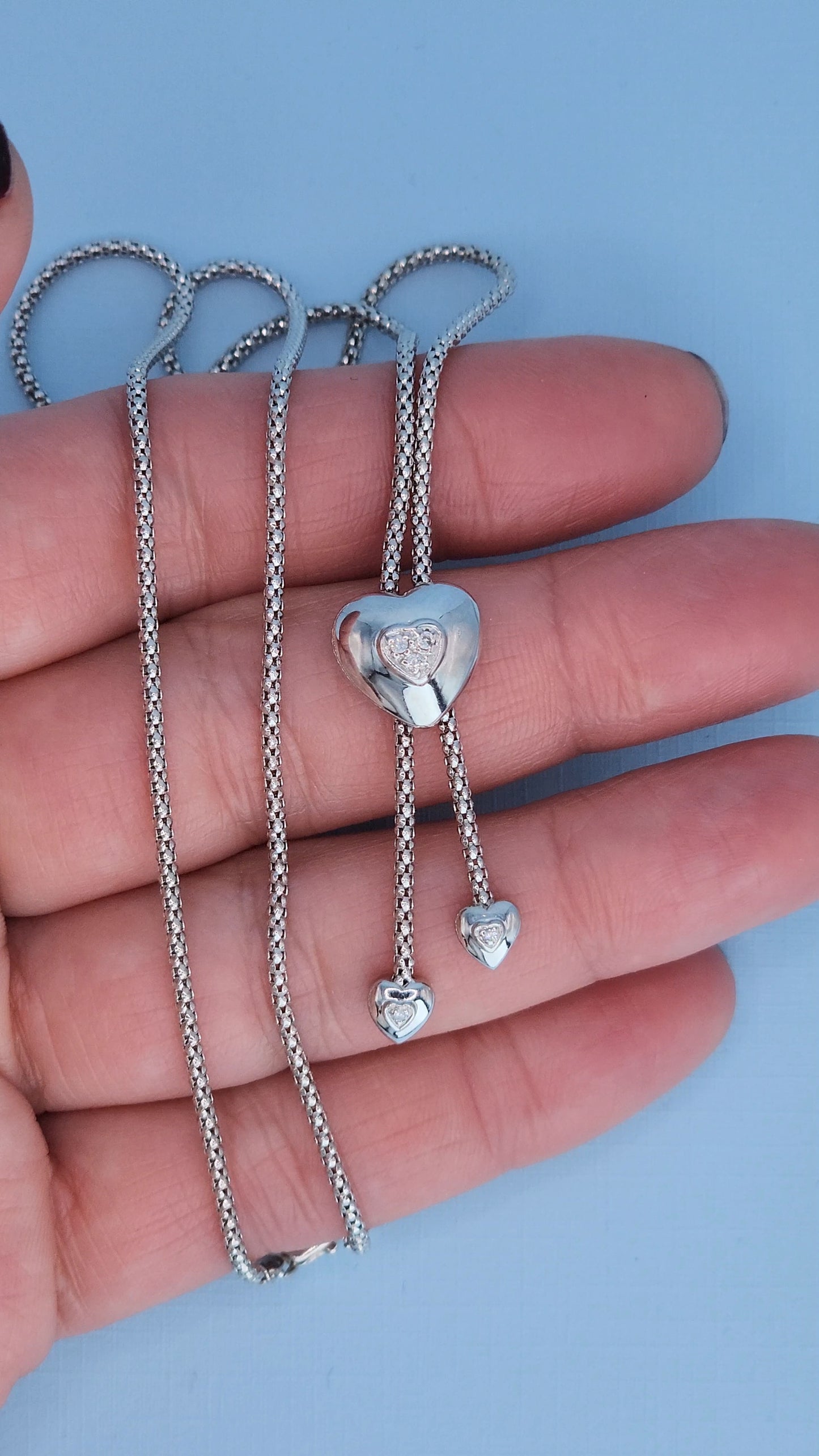 Elegant diamond heart necklace worn on neckline showing lariat drop length