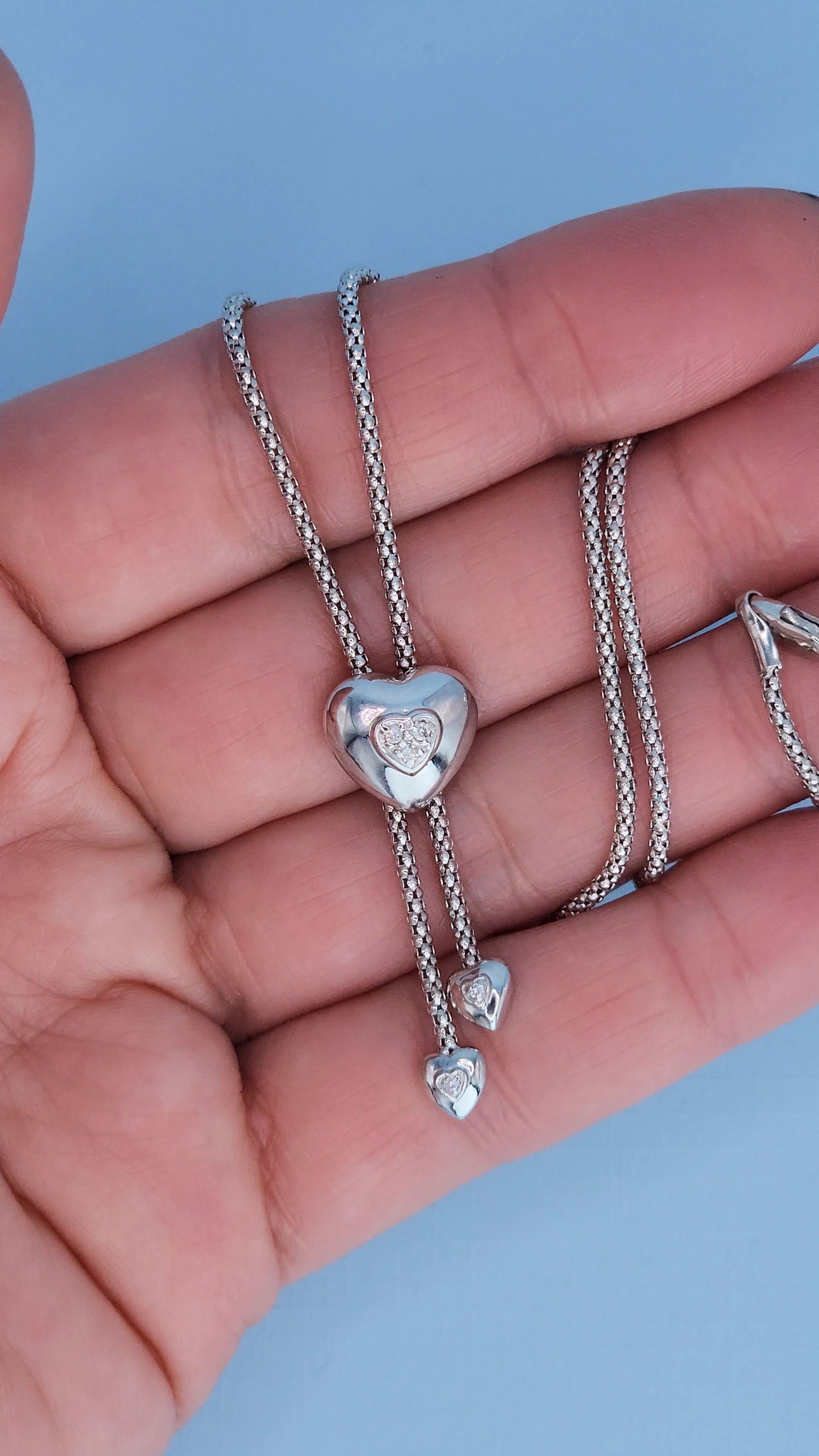 Close-up of heart-shaped lariat necklace showing natural diamond accents