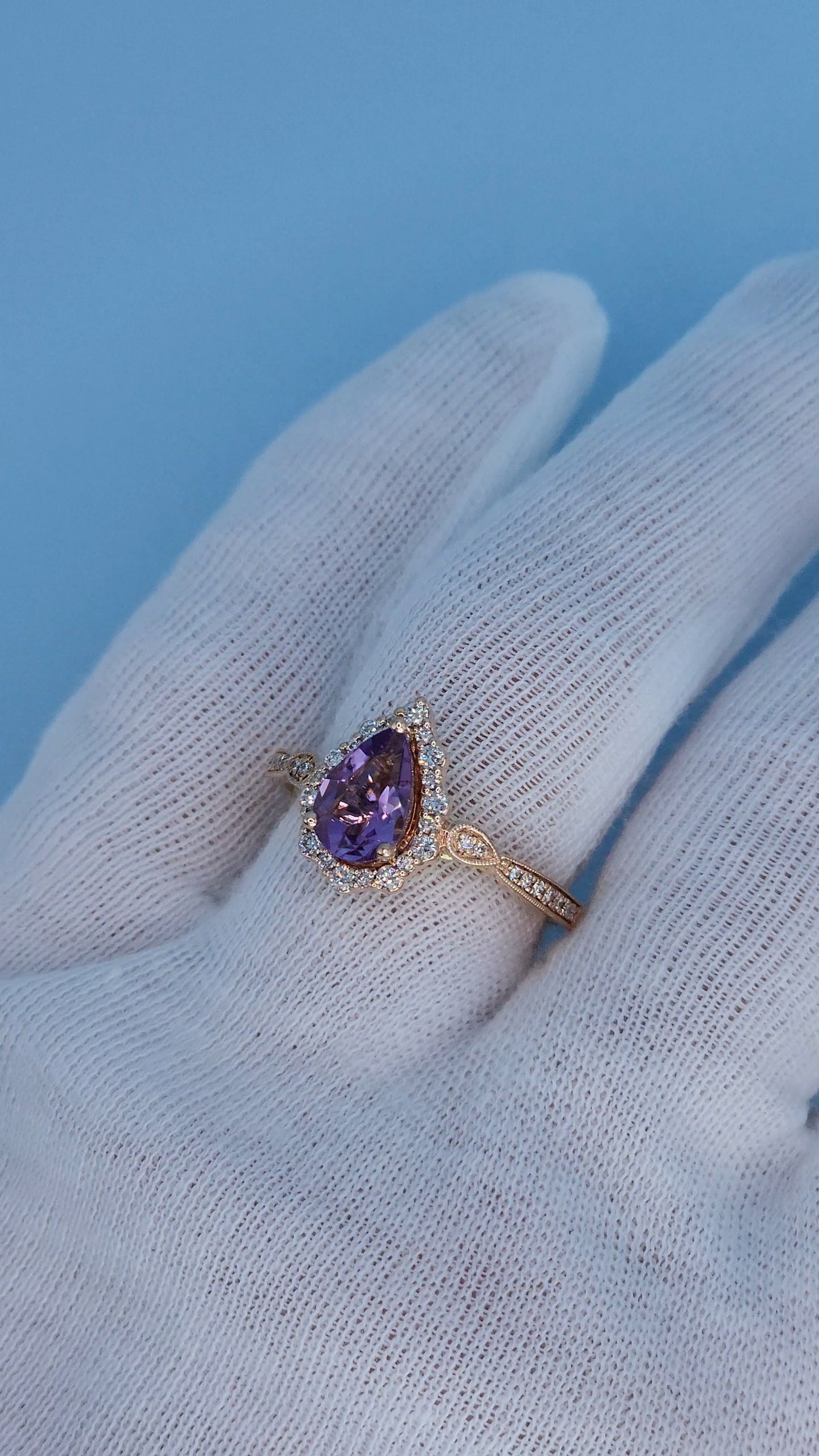 Close-up of pear shape amethyst ring with alternating diamond halo