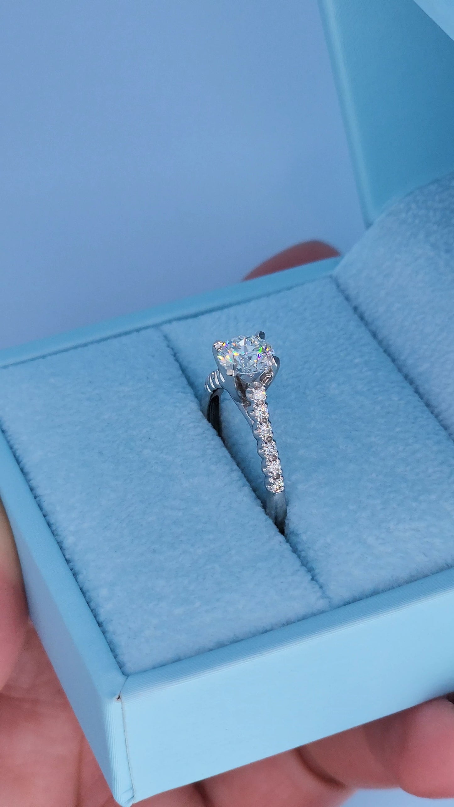 Side view of diamond engagement ring showing cathedral design and accent diamonds