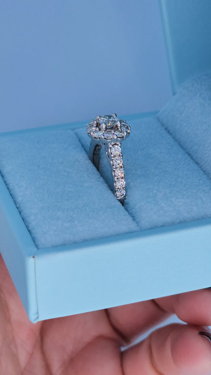 Diamond ring in a light blue jewelry box held by a hand.