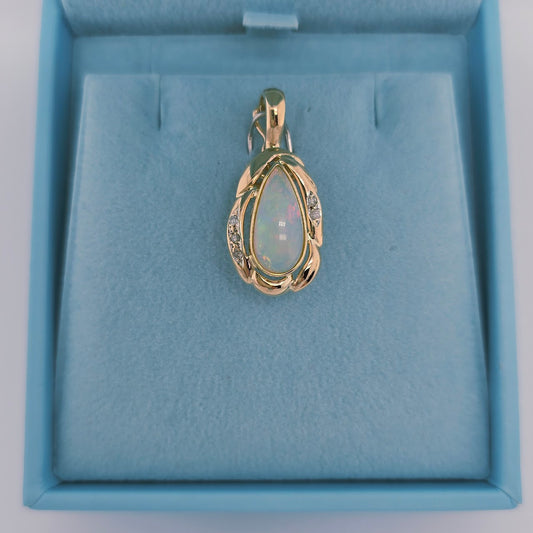 14k yellow gold pendant with a pear-shaped cabochon opal and round diamond accents, designed with a freeform setting and hinged bail for omega chains.